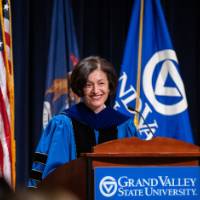 Provost Mili smiles at podium